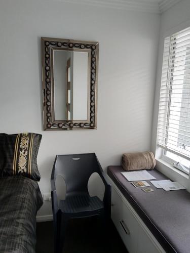a bedroom with a desk with a chair and a mirror at C'est La Vie Bed & Breakfast in Albany