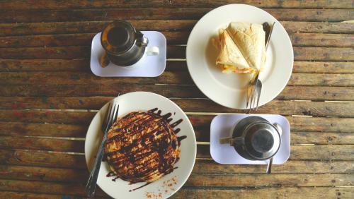 una mesa con platos de comida y tazas de café en Hmong Sister House and Trekking, en Sa Pa