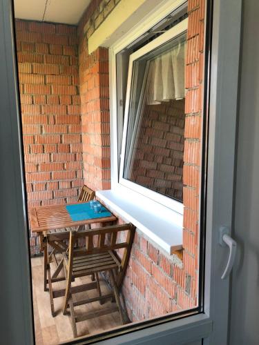 a window with a table and a bench in front of a brick wall at 1-Bedroom apartment in city centre in Paide