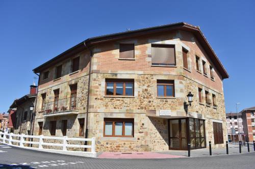 a large brick building with a balcony on a street at Apartamento Rústico in Ochandiano