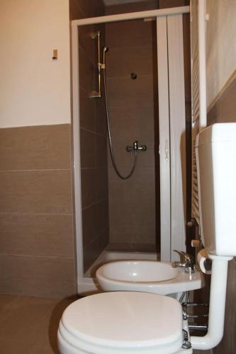 a bathroom with a shower and a toilet and a sink at Casa vacanza le mansardine in Bergamo