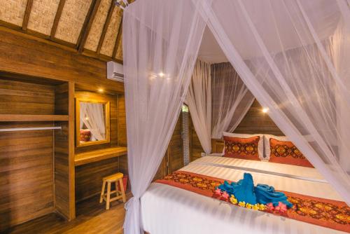 a bedroom with a bed with a canopy at Nerima Hut Lembongan in Nusa Lembongan