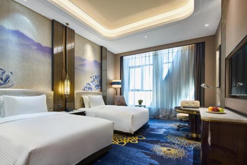 Un ou plusieurs lits dans un hébergement de l'établissement Wanda Vista Hotel Urumqi