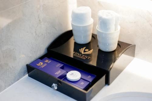 a black box with two candles on top of a toilet at Vincent Halong Hotel in Ha Long