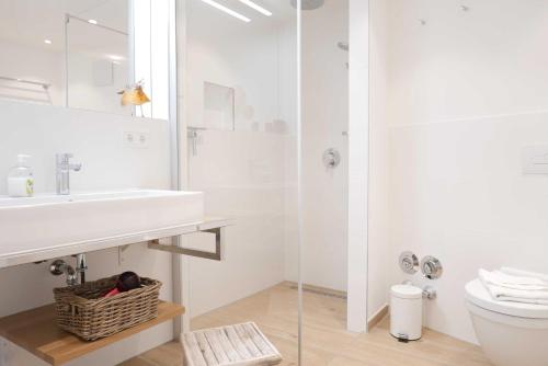 a white bathroom with a sink and a toilet at Baabe Villen Ensemble FeWo 16 Klei in Baabe
