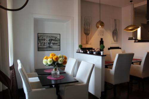 ein Esszimmer mit einem Tisch und weißen Stühlen in der Unterkunft Relais La Maison De Luxe in Rom