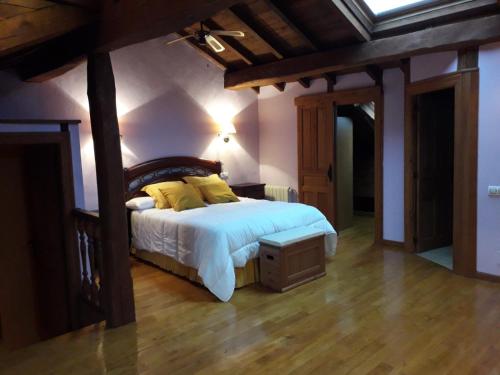 a bedroom with a bed with white sheets and yellow pillows at Casa Serafo in Saliencia