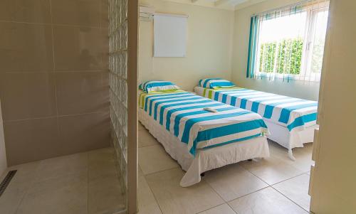 two beds in a room with a window at Hacienda Wayaca Apartments in Wayaca