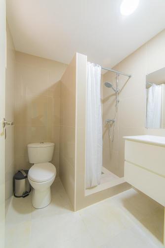 a bathroom with a toilet and a shower and a sink at Hacienda Wayaca Apartments in Wayaca