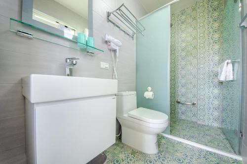 y baño con aseo, lavabo y ducha. en Chi's House B&B, en Taitung