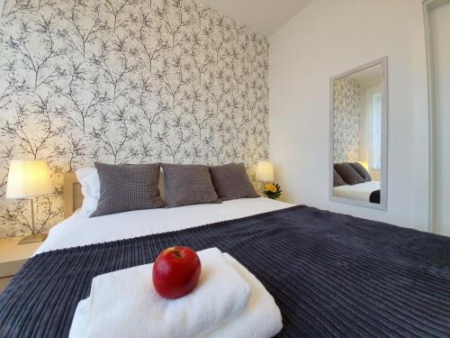 a bedroom with a bed with an apple on top of it at Apartament Azure 19 - 365PAM in Kołobrzeg