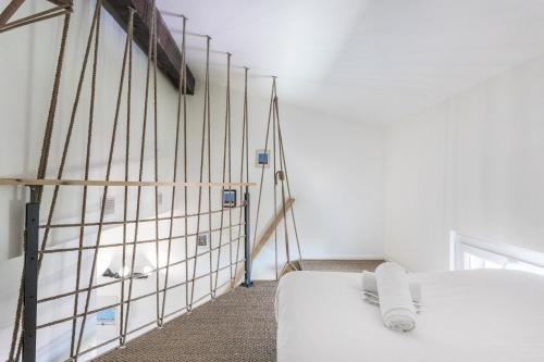 ボルドーにあるDuplex lumineux au coeur de Bordeaux avec Parkingの白いベッド1台、窓のある壁が備わる客室です。