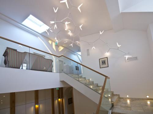 a staircase with a chandelier in a building at Pałac Pakoszów Schlosshotel Wernersdorf in Jelenia Góra