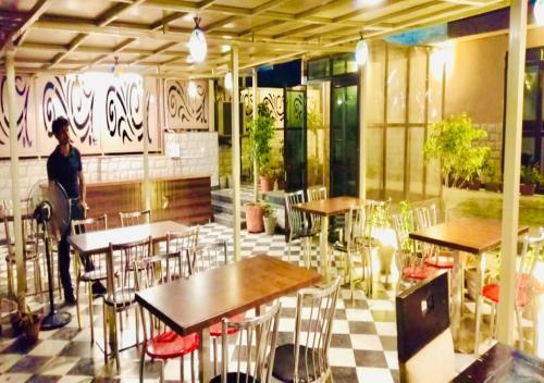 a person standing in a restaurant with tables and chairs at The Grand Uddhav in New Delhi