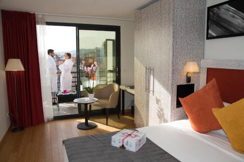 a hotel room with a bed and people standing outside the window at Eden Hotel & Spa in Cannes
