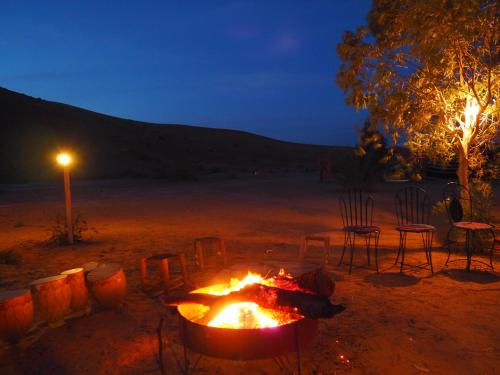 a fire pit in the middle of a desert at night at Maison d'hôtes Dar Farhana in Ouarzazate