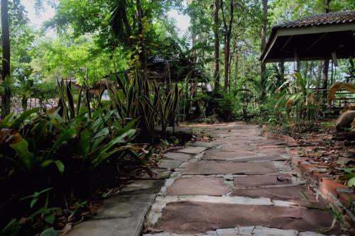 a stone path in the middle of a forest at Promma Farm Resort in Ban Tat Ton (1)