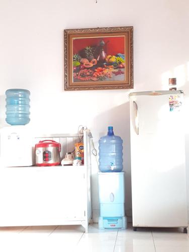 占碑市的住宿－Almira Homestay near Airport，厨房配有冰箱,墙上挂着一幅画