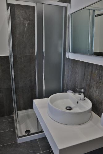 a bathroom with a white sink and a shower at Fiore di Loto Rooms in Carini