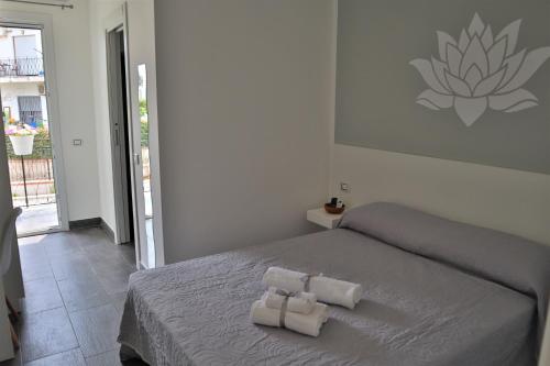 a bedroom with a bed with two towels on it at Fiore di Loto Rooms in Carini