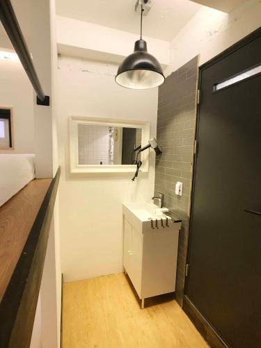 a bathroom with a sink and a black door at Seoul Cube Itaewon in Seoul