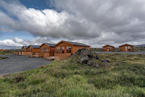 rząd drewnianych domów na polu w obiekcie Dimmuborgir Guesthouse w mieście Mývatn