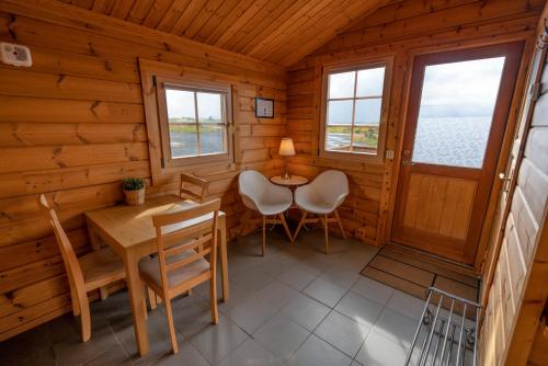 comedor en una cabaña de madera con mesa y sillas en Dimmuborgir Guesthouse, en Myvatn