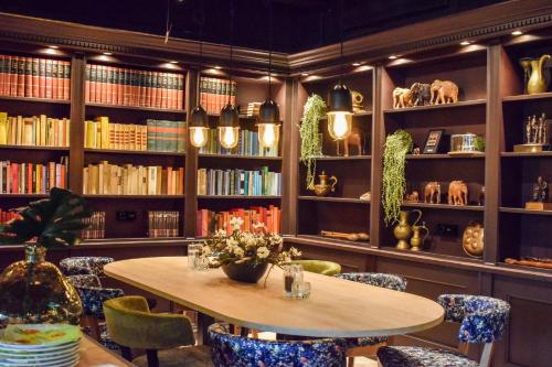 a library with a table and chairs and books at De Borgh in Zevenbergen