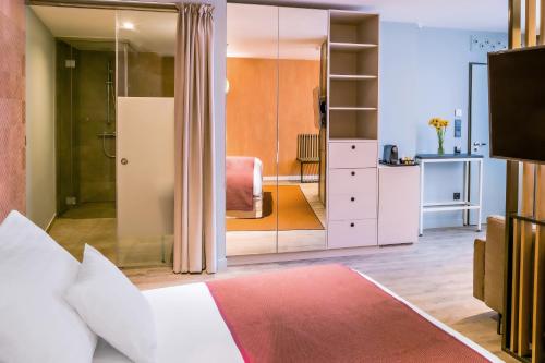 a bedroom with a bed and a sliding glass door at Cortile Hotel - Adults Only in Budapest