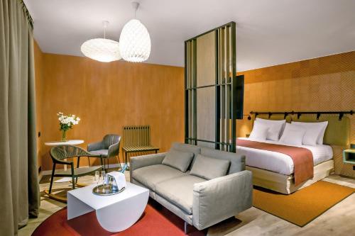 a hotel room with a bed and a couch at Cortile Hotel - Adults Only in Budapest