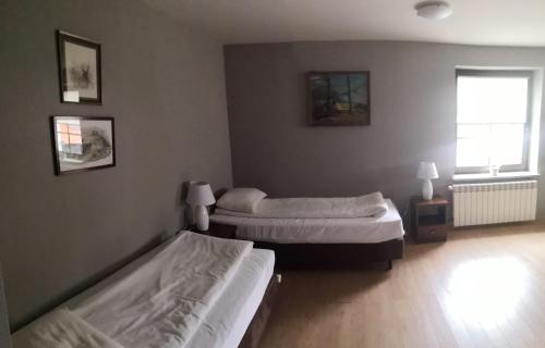 a bedroom with two beds and a window at Hotel Folwark in Zgierz