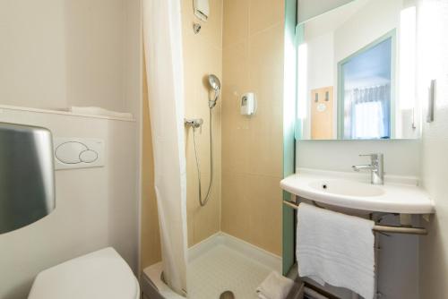une salle de bain avec une douche, un lavabo et des toilettes dans l'établissement B&B HOTEL Antibes Sophia Le Relais, à Biot