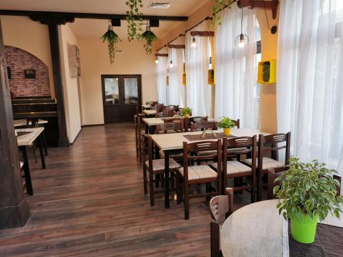 a restaurant with tables and chairs and a piano at Комплекс Антик in Troyan