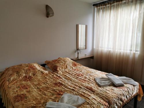 a bedroom with a bed with two towels on it at Комплекс Антик in Troyan