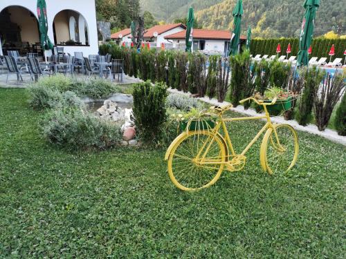 a yellow bike parked in the grass in a yard at Комплекс Антик in Troyan