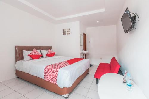 a bedroom with a large bed with red pillows at OYO 947 Angel Home Stay Syariah Near Atrium Pondok Gede, Museum Monumen Pancasila, Taman Mini in Jakarta
