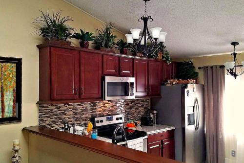 a kitchen with red cabinets with potted plants on top at A Private Bedroom in Orlando