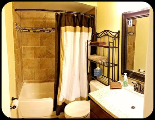 a bathroom with a tub and a toilet and a sink at A Private Bedroom in Orlando