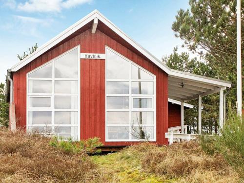 Sønderbyにある4 person holiday home in R mの丘の上に大きな窓のある赤い家