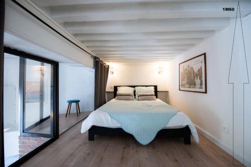 a bedroom with a bed and a large window at Le Ferratière - Moderne industriel du Vieux Lyon in Lyon