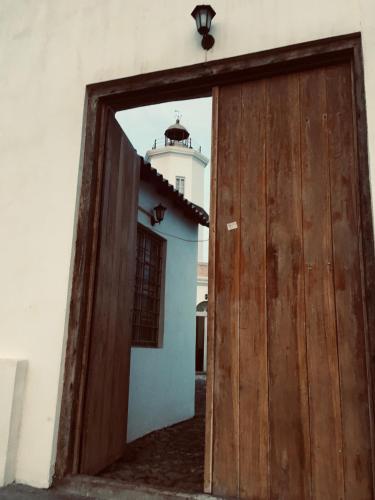 an open door to a building with a lighthouse in the background at Casa Sodadi in Praia