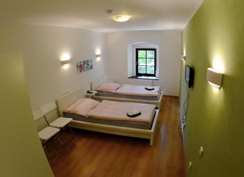 two beds in a small room with a window at pension N.10 in Frymburk