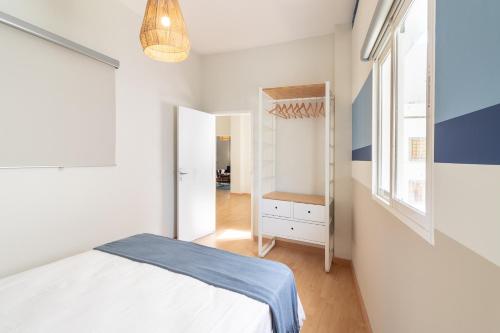 Habitación blanca con cama y ventana en Flatguest Agaete Blue, en Agaete