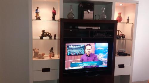 einen TV in einem Bücherregal mit einem TV darin in der Unterkunft Paradise Room in Rio de Janeiro