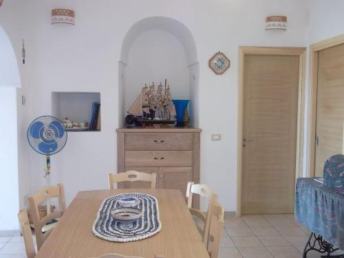 - une salle à manger avec une table et des chaises en bois dans l'établissement Dammuso Levante in c/da Tracino a Pantelleria, à Pantelleria