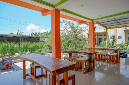 a group of tables and chairs on a patio at RedDoorz near Taman Makam Pahlawan Tatura in Palu