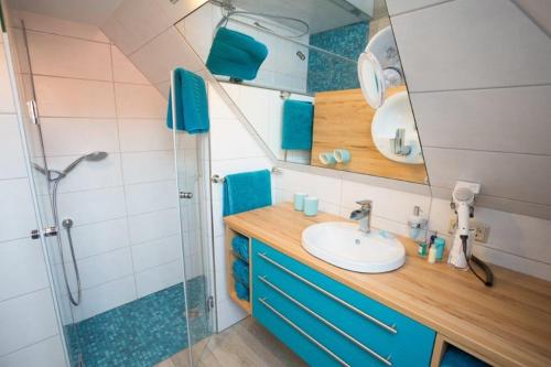 uma casa de banho com um lavatório e um chuveiro em Ferienwohnung Harztraum em Bad Sachsa