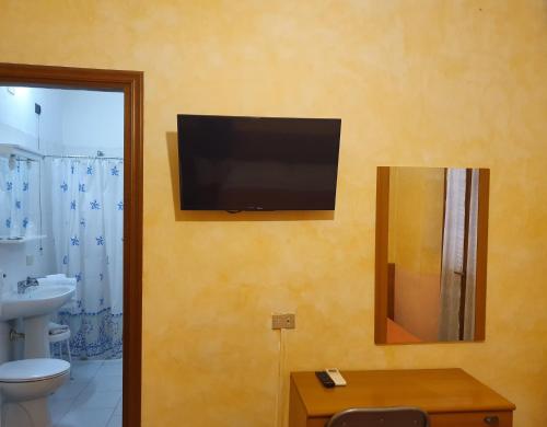 Televízia a/alebo spoločenská miestnosť v ubytovaní Albergo Leon d'Oro