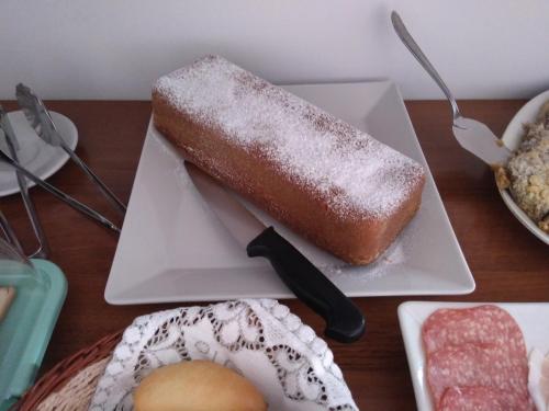 a white plate with a piece of bread and a knife at B&B Casa Alessio in Santa Domenica