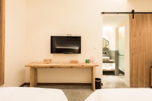 a room with a table with a tv on the wall at Yunshan Villa in Huangshan Scenic Area